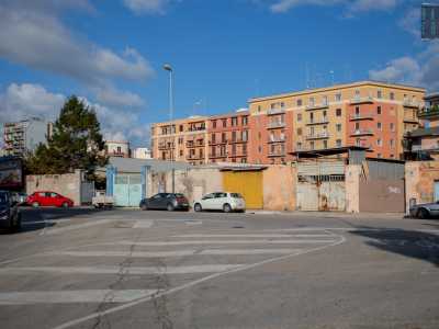 Sul marciapiede si susseguono altri colorati e scalcinati cancelli in ferro